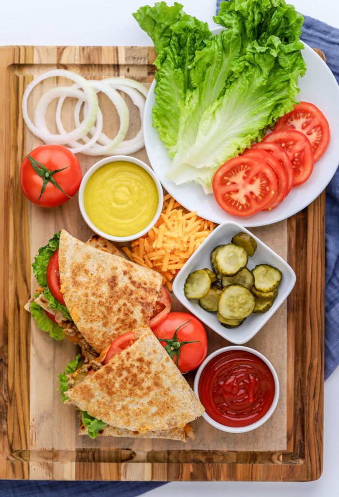 Cheeseburger Quesadilla on a board with extra toppings