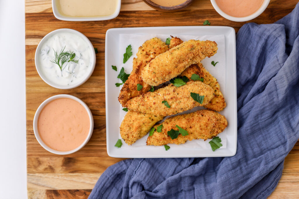 Air Fryer Chicken Tenders on a white plate with 2 different dips