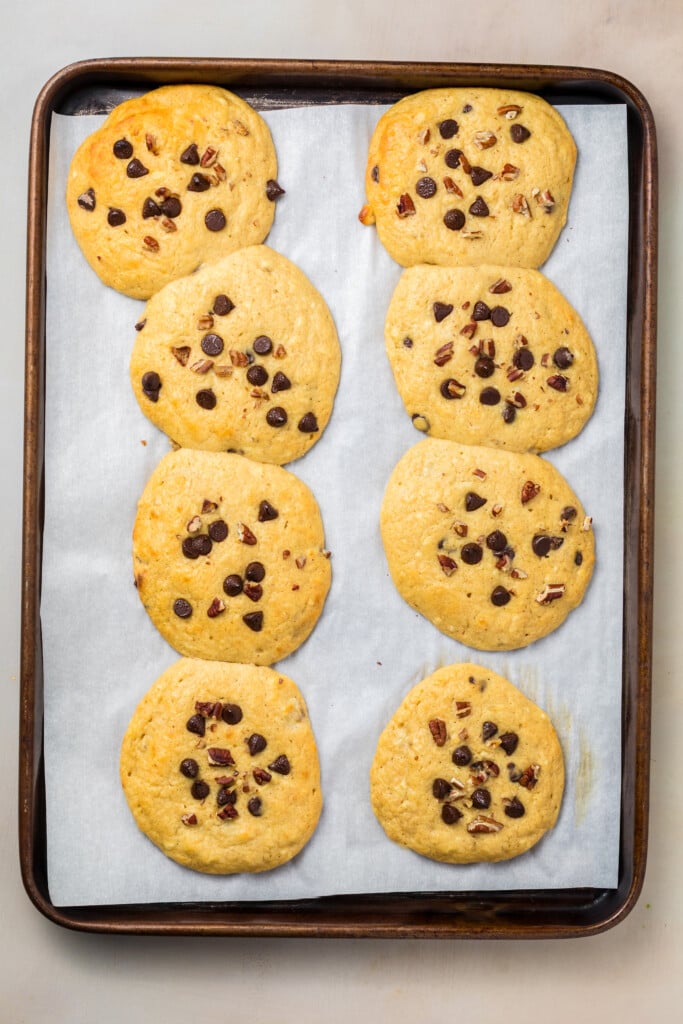 Freshly baked banana chocolate chip protein pastries on a baking sheet.