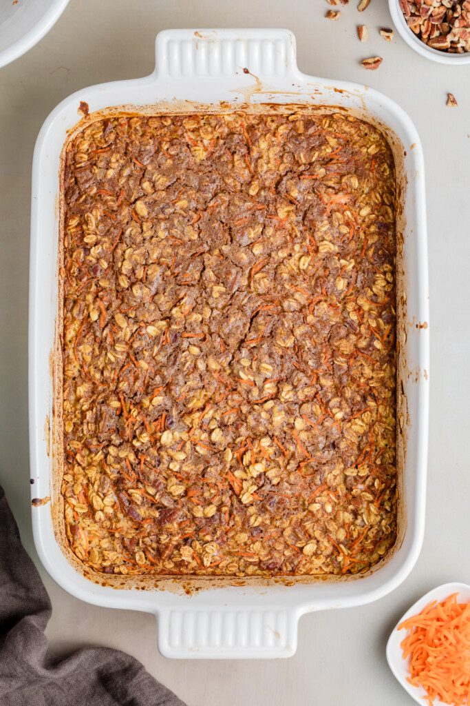 Golden-brown carrot cake baked oatmeal just baked in a white casserole dish.