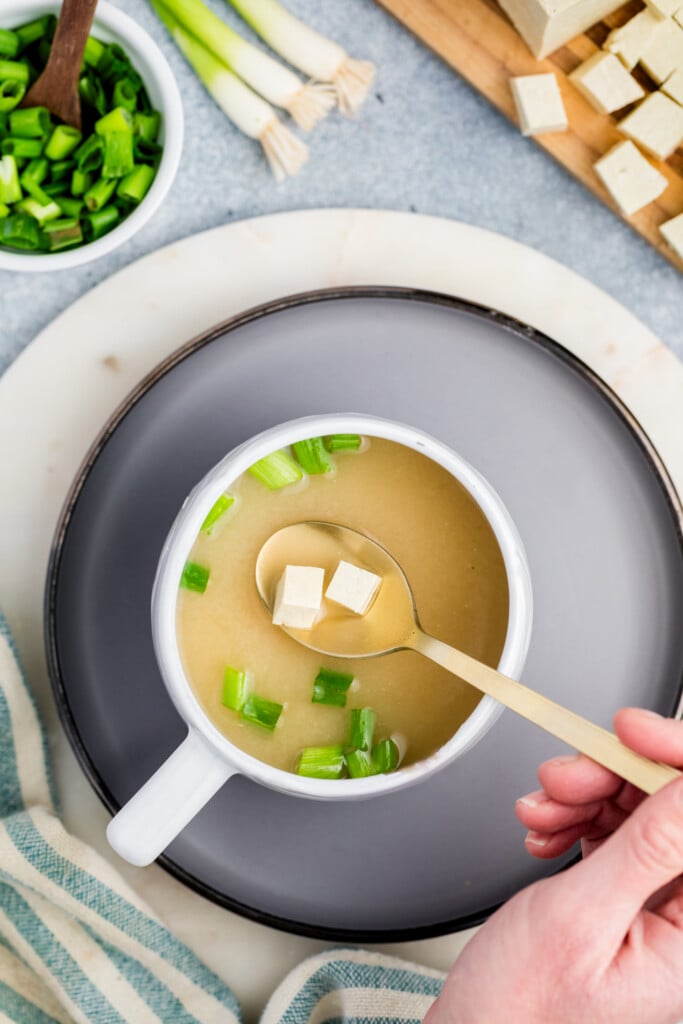 A spoon in a mug of soup.