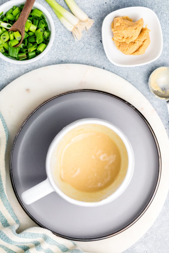 A cup of soup on a plate.