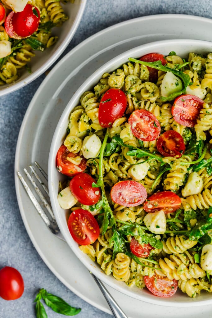 Close-up of a vibrant Pesto Caprese Pasta Salad, featuring fresh cherry tomatoes and creamy mozzarella balls tossed with flavorful pesto.