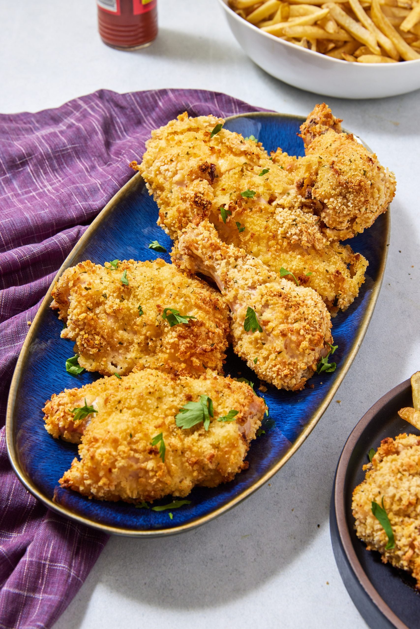 A platter of breaded, oven-fried chicken pieces garnished with parsley, perfect for recipes to lower blood pressure.